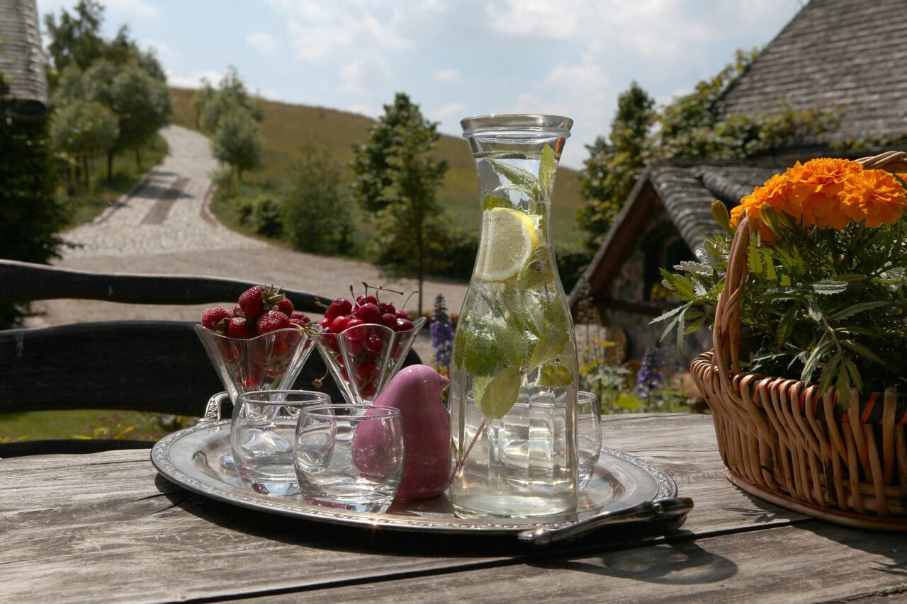 wasser, gläser und blumen stehen auf einem holztisch