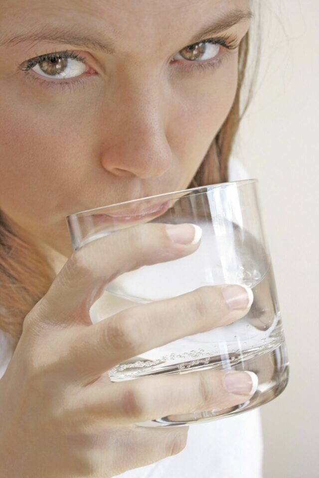 frau trinkt wasser aus einem glas