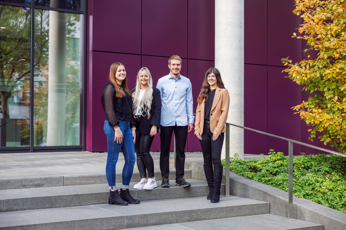drei junge frauen und ein mann auf einer treppe