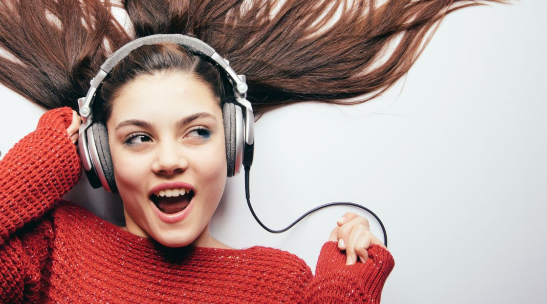 lachende frau mit langen haaren und kopfhörern